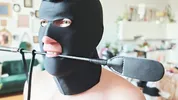 A sex slave in a cock cage has his balls whipped by a dominatrix while, right before her eyes, he sucks his Master's cock until he cums on him.